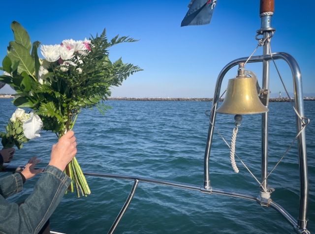 家族が海に手を合わせる写真